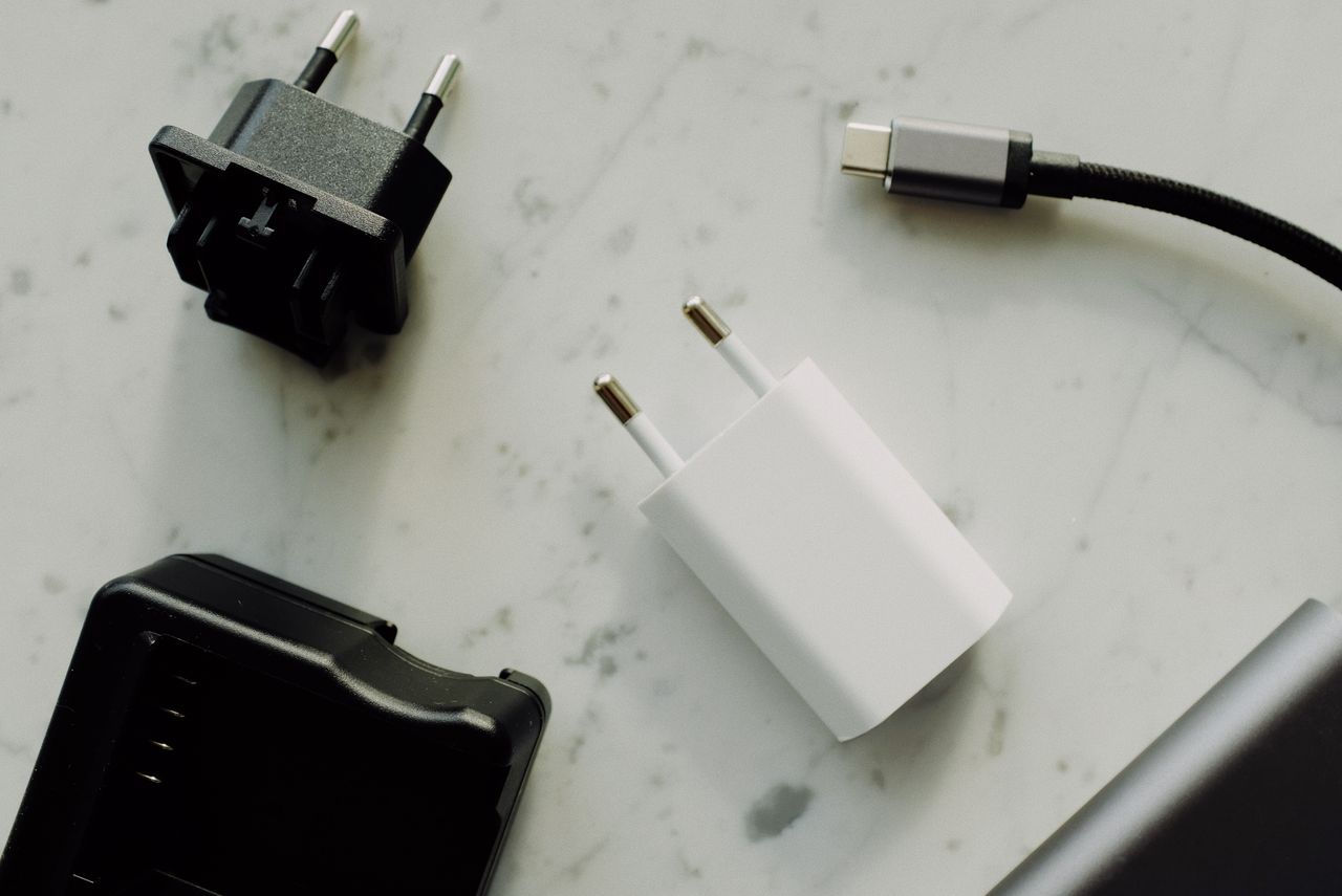 Adaptadores de corriente y cable USB-C sobre superficie blanca