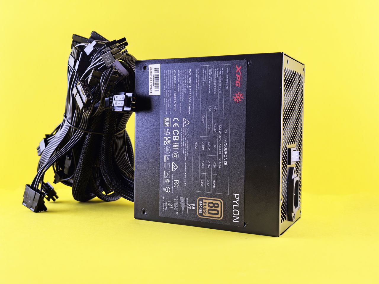 Fuente de alimentaciテウn negra con cables sobre fondo amarillo