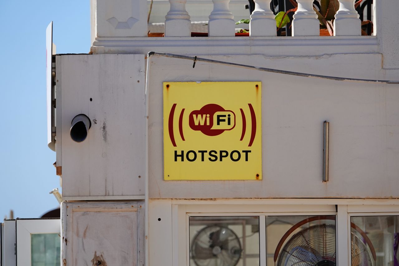 Letrero amarillo de wifi en una fachada