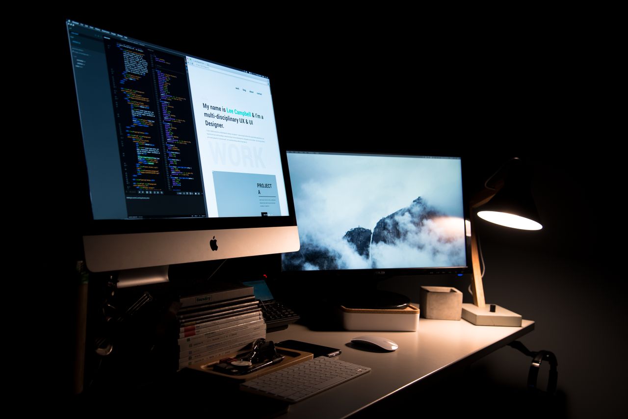 Espacio de trabajo con dos monitores y una lámpara